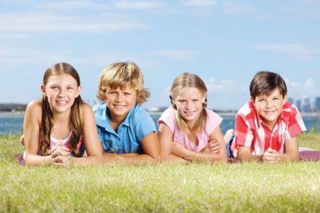 Does my child need braces? Kids smiling in a field